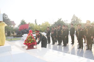 ຊາວໜຸ່ມກະຊວງປ້ອງກັນປະເທດວາງກະຕ່າດອກໄມ້ຢູ່ໜ້າຮູບປັ້ນຫຼໍ່ປະທານໄກສອນ ພົມວິຫານ